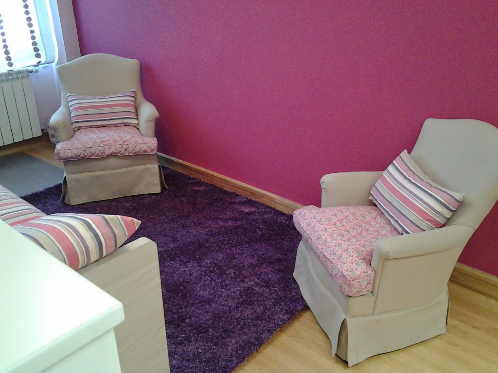 Conjunto butacas tapizadas y alfombra, pared color fresa