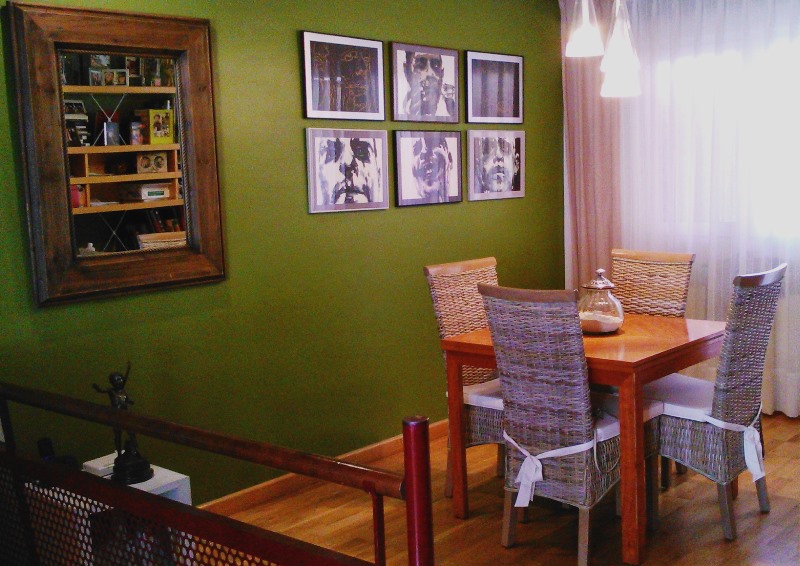 Comedor en verde sillas de rattan composición cuadros espejo